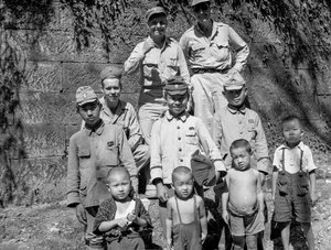 Amerikai katonák a japán családdal együtt pózolnak a japán kapituláció után, és...
