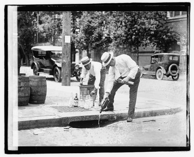 Két férfi szeszesitalt tölt a csapadékcsatornába, 1921. július 8. (f/w fotó) alkotó: American Photographer