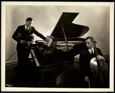 Vak nő, Harding kisasszony, a zongoránál két vak férfit oktat a hegedűn és csellón, 1936 (ezüst zselatin nyomat) alkotó: Byron Company