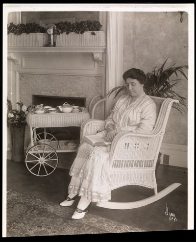 Mrs. Howard egy könyvvel ül egy hintaszékben az 5. sugárút 200. szám alatti otthonában, New York, 1915-6 (ezüstzselatinos nyomat) alkotó: Byron Company