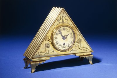 Háromszög alakú sárgaréz asztali óra gravírozott virágdíszítéssel (sárgaréz) alkotó: Dagobert (attr. to) Peche