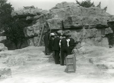 Egy csoport állattartó, aki kipakolja a szent páviánokat a londoni állatkert „Monkey Hill” sziklái között alkotó: Frederick William Bond