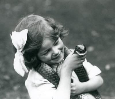 Egy fiatal lány, Betty, aki egy keleti indigókígyót tart a kezében, a londoni állatkertben, 1924 alkotó: Frederick William Bond