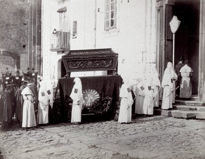 A nápolyi San Francesco Kongregáció temetési menete. Az előtérben, egy templom előtt számos fehér tunikás és csuklyás „társi testvér” kíséri a hímzett ruhával díszített katafalkot, amelyre a koporsót helyezik. alkotó: Giorgio Sommer