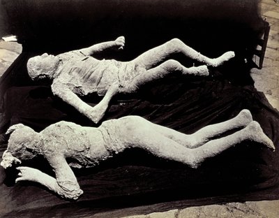 Két öntvény emberalakokból Pompei ásatásairól. A kiállított tárgyakat fekete vászonra helyezték, hogy lefotózzák őket alkotó: Giorgio Sommer