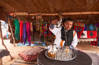 Egy helyi mentateát szolgál fel a marokkói Erg Chebbi sivatagban, Merzouga közelében, Marokkó, 2019 (fotó) alkotó: Ira Block