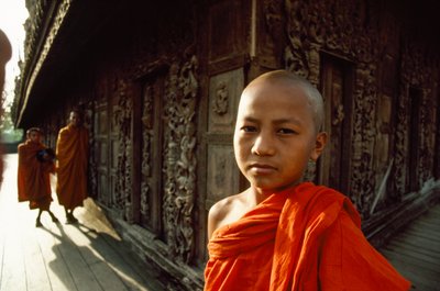 Egy fiatal novícius szerzetes a faragott teakfa panelek előtt. Shwenandaw kolostor, Mandalay, Burma. alkotó: James L Stanfield