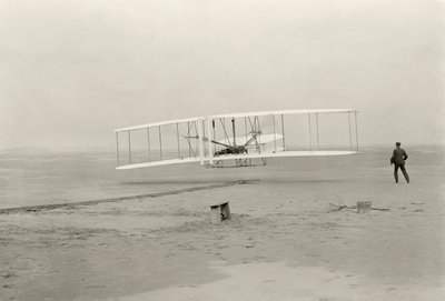 A Wright Flyer I első 120 láb magas repülését 12 másodperc alatt teszi meg az észak-karolinai Kitty Hawkban alkotó: John T. Daniels