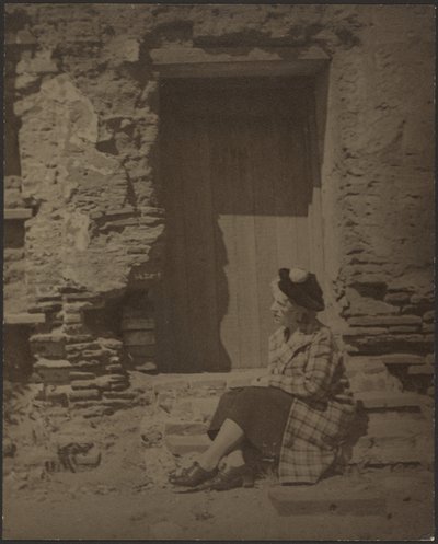 [Nő ül a romló épület előtt] alkotó: Louis Fleckenstein
