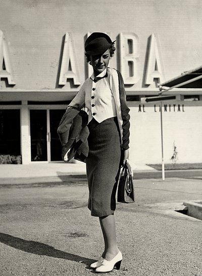 A "Graldi" couture ház által készített modell viselet együttes. Az öltözet egy öltönyből és kétszínű blúzból áll. Egy merev kalap teszi teljessé az együttest. (f/w fotó) alkotó: Luis Bogino
