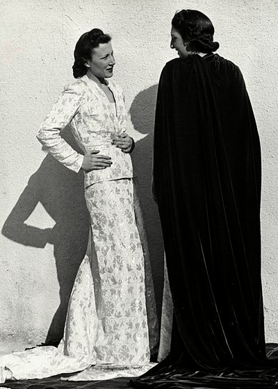 Két modell az olasz "Dragoni" couture ház alkotásait mutatja be. Az egyik modell pelenkázott anyagból készült ruhát visel, amely kabátból és hosszú szoknyából áll. A másik modell hátulról nézve hosszú bársonyköpenyt visel. (f/w fotó) alkotó: Luis Bogino