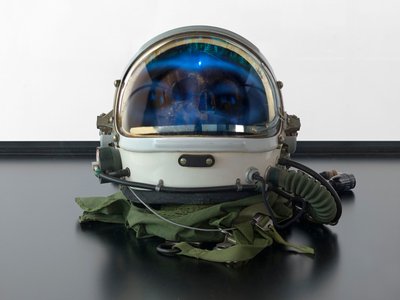 Alpha Omega, 2016 (Üveg, LCD képernyő, médialejátszó, koponyareplika, űrsisak, fa) alkotó: Mat Collishaw