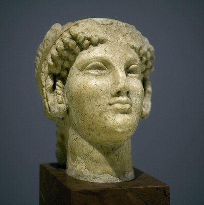 Lányfej (Kore), a római hellenisztikus kor szobra (korszakunk utáni 3. 2. század), nagyon kifejező arc, kiemelkedő arccsont kelet felé, mosoly, göndör haj, Ionie archaikus stílusa a korszakunk előtti 6. században, amely sokáig állandósult után alkotó: Roman