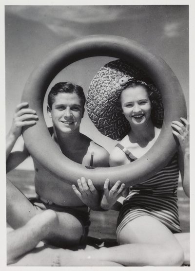 Férfi és nő egy gumigyűrűn keresztül néz a tengerparton, 1935 alkotó: Unbekannt