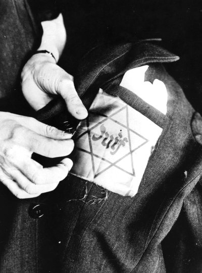 A zsidót azonosító sárga csillag felvarrása egy kabátra, németek által megszállt Párizs, 1942 alkotó: Unbekannt