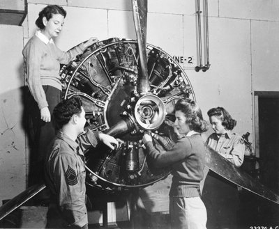 A darazsak megtanulják, honnan származik az erő a B-17 Flying Fortress hajtóművében, miközben részt vesz a B-17 pilótaképzésen a Lockbourne AAB-nál, a propeller mechanizmuson dolgoznak, miközben a legénység vezetője nézi őket (lr): Patricia Bowser, Ann Wal alkotó: Benjamin Baud