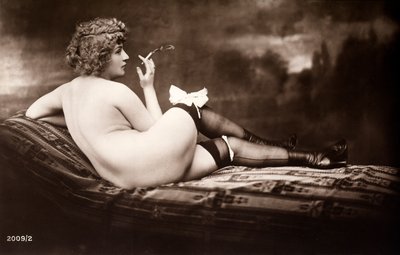 Portré egy fiatal nőről, aki meztelenül, hátat fordítva, cigarettázik, pózol. alkotó: Unknown photographer