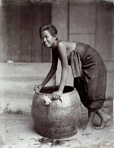 Fiatal, mosolygós thaiföldi nő, aki egy nagy konténert tologat alkotó: Unknown photographer