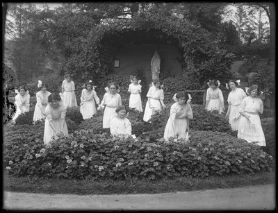 Leányok végzős osztálya a Római Katolikus Árvaszállóból a virágoskertben, a Szűz Mária barlang előtt, 1912 bw fotó alkotó: William Davis Hassler