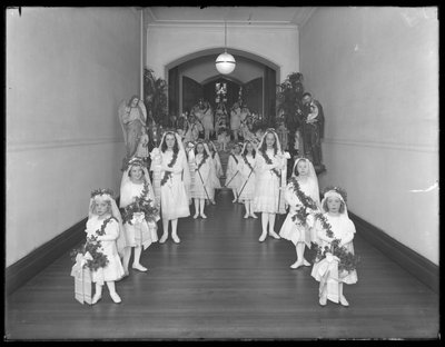 Kislányok a bronxi Kingsbridge-i római katolikus árvamenhelyen, fehér ruhákban, koszorúkkal és füzérekkel térnek vissza a kápolnából, 1914. október 20. alkotó: William Davis Hassler