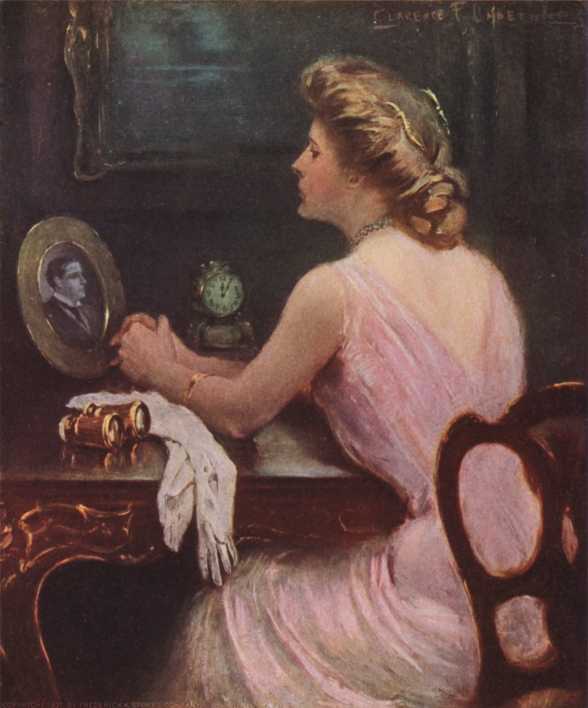Nő ül a fésülködőasztalánál, és egy férfi, esetleg férje vagy szeretője fényképét nézi alkotó: Clarence F. Underwood