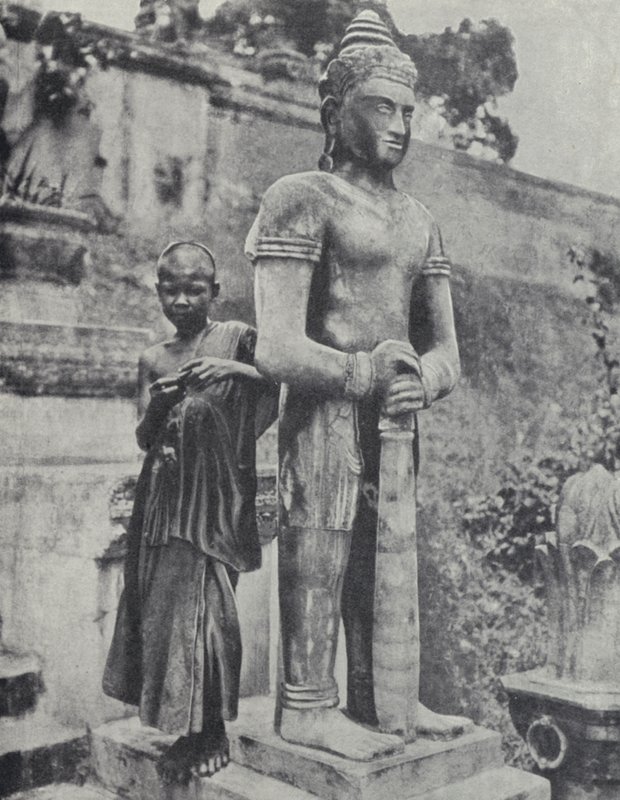 Fiatal buddhista újonc szerzetes egy Buddha-szobor mellett, francia Indokína (f/w fotó) alkotó: Ewing Galloway