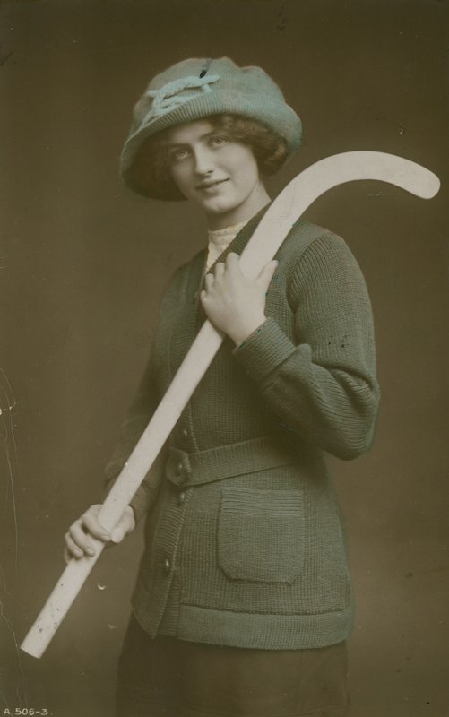 1913-ban elküldött képeslap egy fiatal nőről, aki vállán hokiütőt hord alkotó: French Photographer