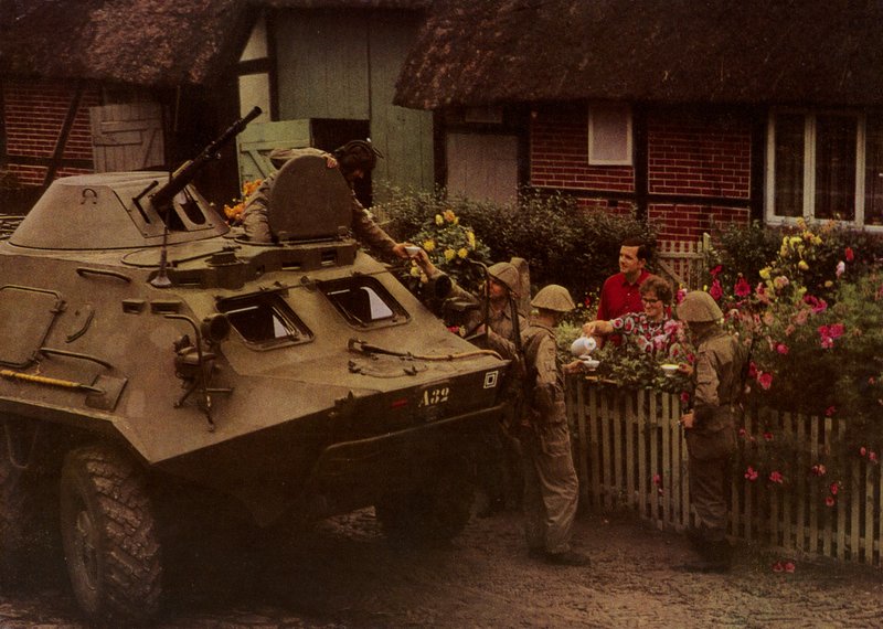 Pihenő közben menet közben az Országos Néphadsereg katonáit szívélyesen fogadják a lakosok (színes fotó) alkotó: Photographer German
