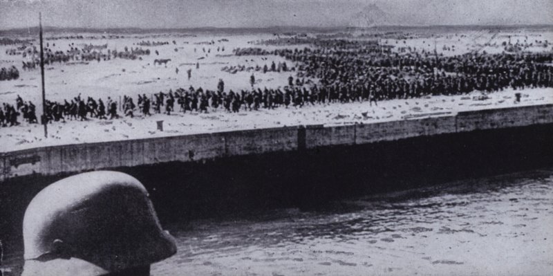 Német katona szövetséges foglyokat vizsgál a franciaországi Dunkerque tengerpartján, II. világháború, 1940. június (f/w fotó) alkotó: Photographer German