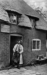 Egy férfi pipázik egy bolt előtt, Worcestershire, 1922.