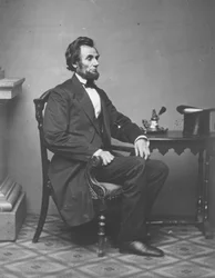 Abraham Lincoln, egészalakos portré, ülő, 1861