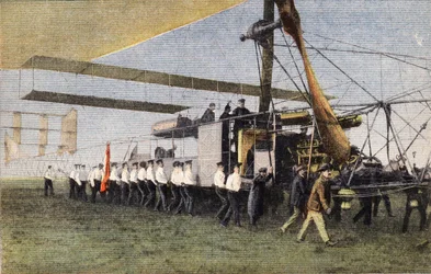 Compiegne-ből Londonba léghajóval: angol katonák vontatják a Bayard-Clement léghajót a Wormwood Scrubbs-i hangárjában. Metszés. A „Le petit parisien” című újság egyike 1910.10.30. Magángyűjtemény.