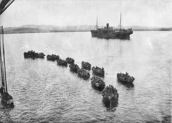 Az ausztrál csapatokat öngyújtókkal vontatják a partra, hogy partra szálljanak a gallipoli Anzac Cove-nál. A háttérben a szállítóhajó, 1915