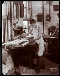 Egy fiatal férfi a Harrington Piano Co. gyárában dolgozik, 1907