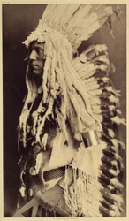 Öreg ember, Piegan. A fiatal férfiak egyetlen nyilvános ünnepséget sem hagynak ki, hogy felvegyék harcos apjuk ruháját. A kép az Edward S. Curtis (1868-1952) által az észak-amerikai indiánokról szóló enciklopédiának 6. kötetéből származik, elől