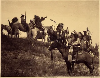 razzia tervezése. Az indiánok lenyűgöző jellegzetes jelmezeikben rendkívül festői csoportokba állnak össze. Ez egy csapat Sioux Ogalala-ból (Oglala), egy dombon, ahonnan kilátás nyílik a Wounded Knee Valley-re a Pine Ridge Reserve-ben, Dél-Dakotában. Fotó 