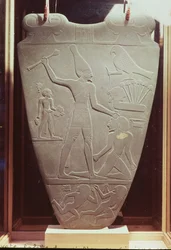 Narmer-paletta: Narmer királyt ábrázoló szertartási paletta, amint Felső-Egyiptom fehér koronáját viselve lesújt egy fogolyra, Hierakonpoliszból, korai dinasztikus kor, Kr. e. 3000 körül (pala) (részlet)