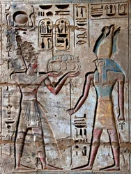 Egyiptomi ókor: első udvar, festett domborművek részlete, amely a fáraót ábrázolja, aki áldozatot vitt az isteni Hórusznak. Ramszesz temetkezési temploma (Kr. e. 1187-1156). Luxor, Medinet Habou, Egyiptom