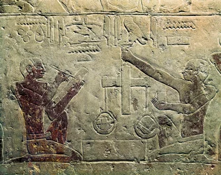 Egy kereskedőt és egy vásárlót ábrázoló domborműves: az egyik figura mérleget használ, míg a másik jegyzetel, Kr.e. 2465-2323