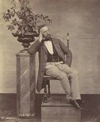 [Mathias Höusermann könyökölve ül a talapzaton, kezében egy váza virágokkal], 1850-60-as évek.