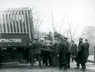 Bámészkodók tömege áll, miközben a londoni állatkertben 1924-ben az állattartók kiraknak egy orrszarvút a teherautóból.