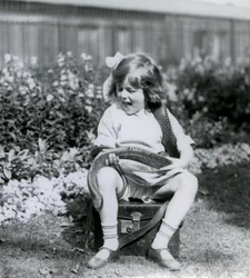 Egy fiatal lány, Betty, kezében egy keleti indigókígyóval, miközben egy bőrládán ül, Londoni Állatkert, 1924