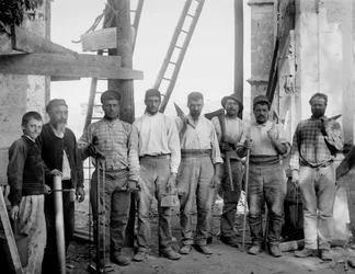 A Bourmont en Haute-Marne (Haute Marne) Septfontaines apátság restaurálásán dolgozó asztaloscsapat szerszámaikkal, baltával, fűrésszel, ólomhuzallal, szabályaikkal és tömegével pózol, 1890 körül. Fényképészet. Ducos kollekció.