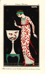 Nő korallmintás selyem háziköntösben, vászon alsószoknyán. Akvárium korallokkal és aranyhalakkal. Robe d’interieur en soie brochee, ouverte sur un dessous de linon. Kézzel színezett pochoir (stencil) rézkarc George Barbier tommasói illusztrációja nyomán