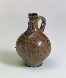 Bartmannkrug vagy Bellarmine borosüveg felhelyezett szakállas arcmaszkkal díszítve, Németország, 1630-40 körül (sómázas kőedény)