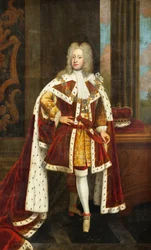 II. György király portréja, amikor Wales hercege, teljes alakban, állami köntösben és a Harisnyakötő Rend gallérjában, bal kezében a kardját és a koronétát az asztalon mellette, a belső térben,