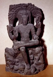 Hinduizmus: Siva egyik megnyilvánulása egy sziklán ülve, négy karral, rózsafüzért, tüzet tartva, a tanítás és az ajándékozás gesztusában. Szobrászat a 12-13. századból Dim. 1,2 m; Dél-Indiából. C.T Loo kollekció