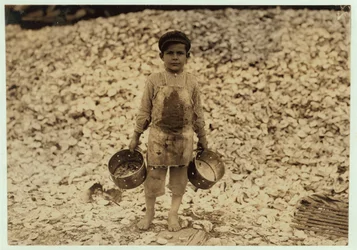5 éves migráns garnélarákszedő Manuel egy halom osztrigahéj előtt, második éve dolgozik Dunbarban, Lopezben, Dukate Company, Biloxi, Mississippi, 1911