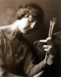 Elisabeth Chaplin festő félalakos portréja. Bal kezében két ecsetet és egy palettát tart