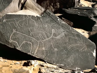 Őstörténet, sziklaművészet: oroszlánokat, antilopokat, struccot és szarvasmarhát ábrázoló sírkő. Kőkorszak Kr.e. 5000-2000. Taghit, Haut Platau du Hoggar, Algéria